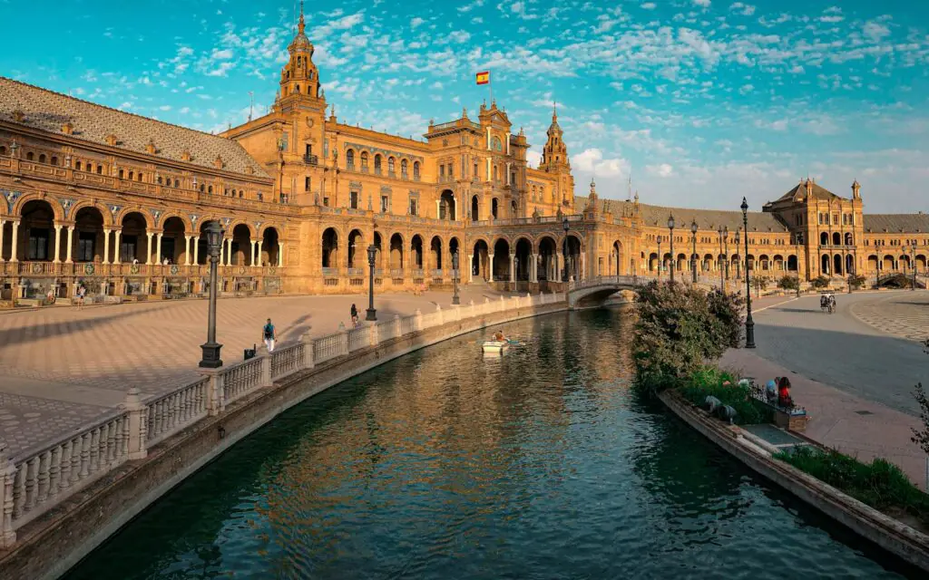 The curved facade and canal of Plaza de España in Seville in golden light