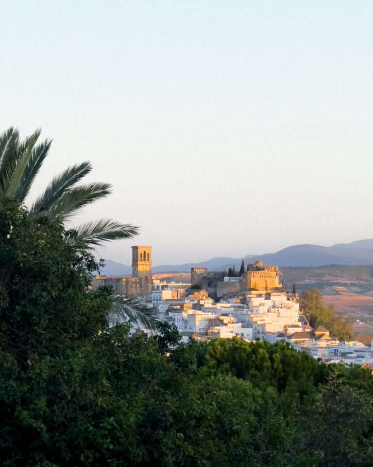Arcos de la Frontera's white houses and towers on their ridge at dusk