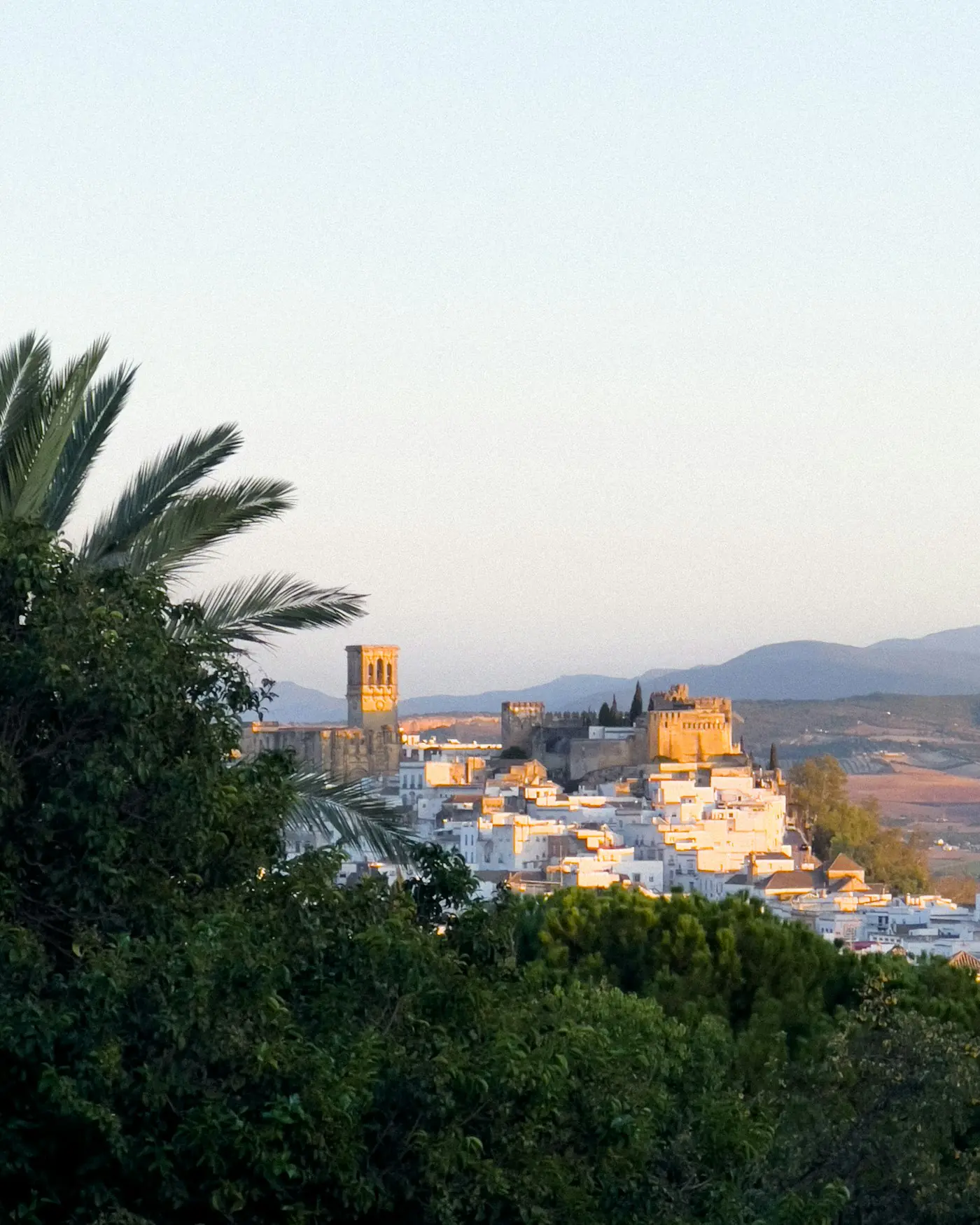 Arcos de la Frontera's white houses and towers on their ridge at dusk